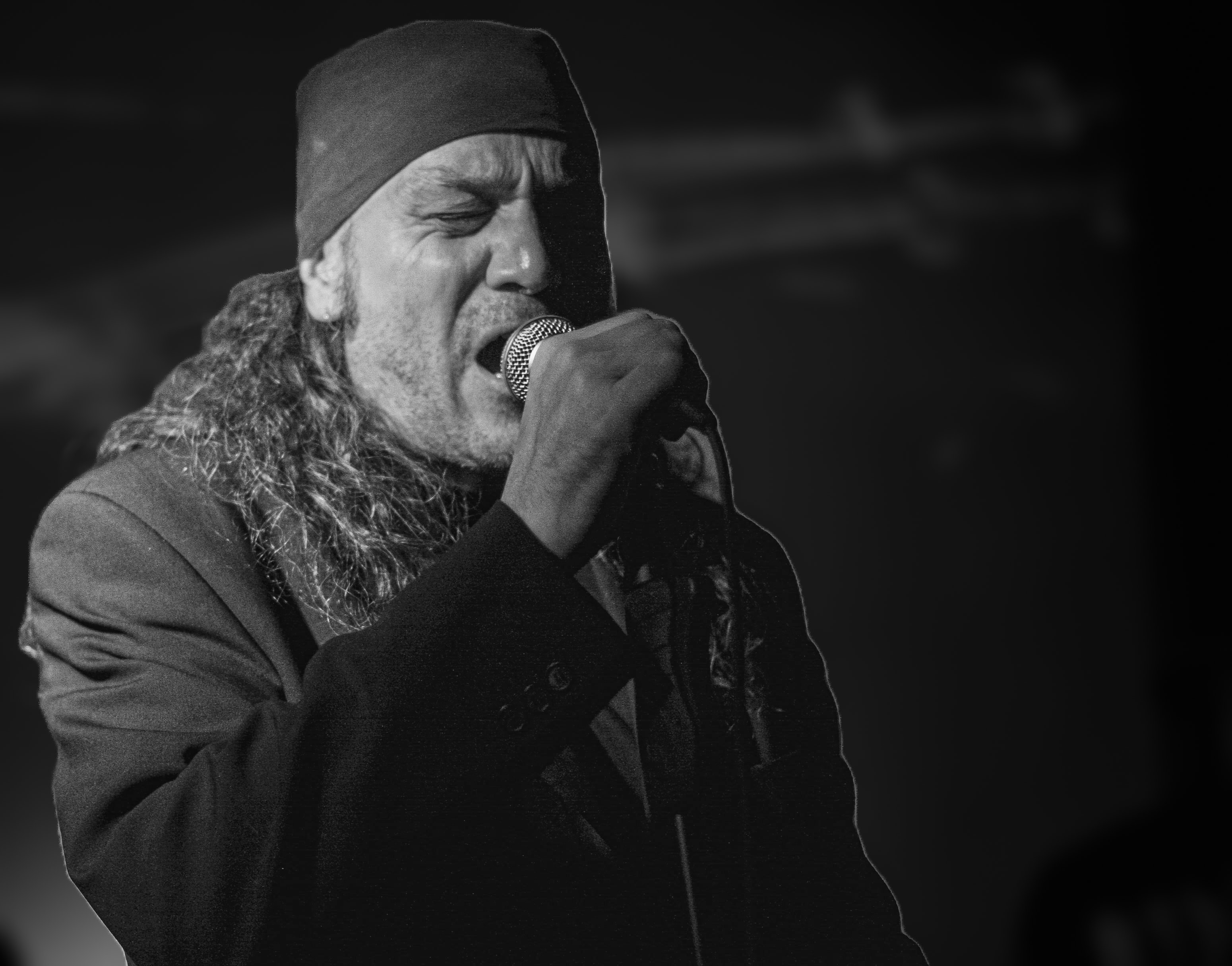 Billy Sharp of The Real Deal singing into a microphone at The Side Cafe, Newcastle