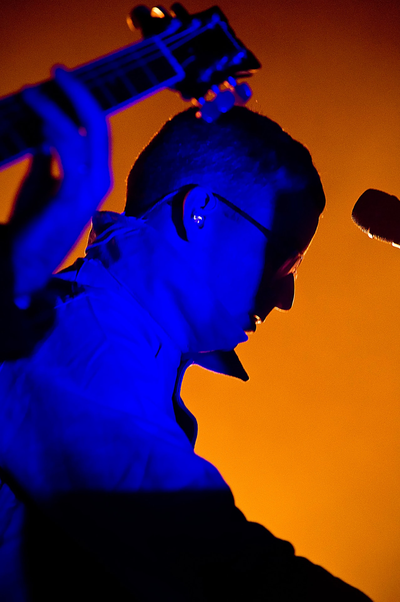 Alexis Taylor of Hot Chip performing live under blue and orange stage lighting