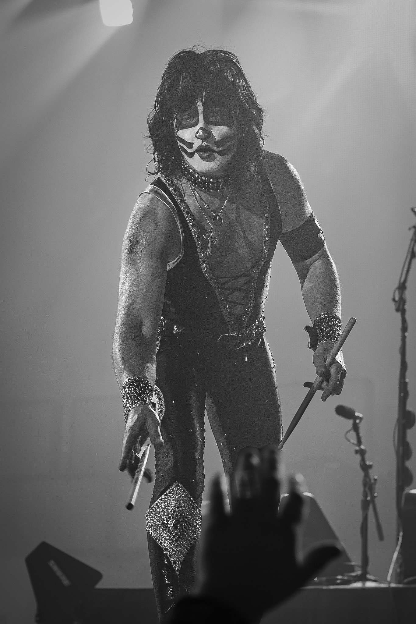 Eric Singer of KISS in full stage makeup and costume holding drumsticks on stage