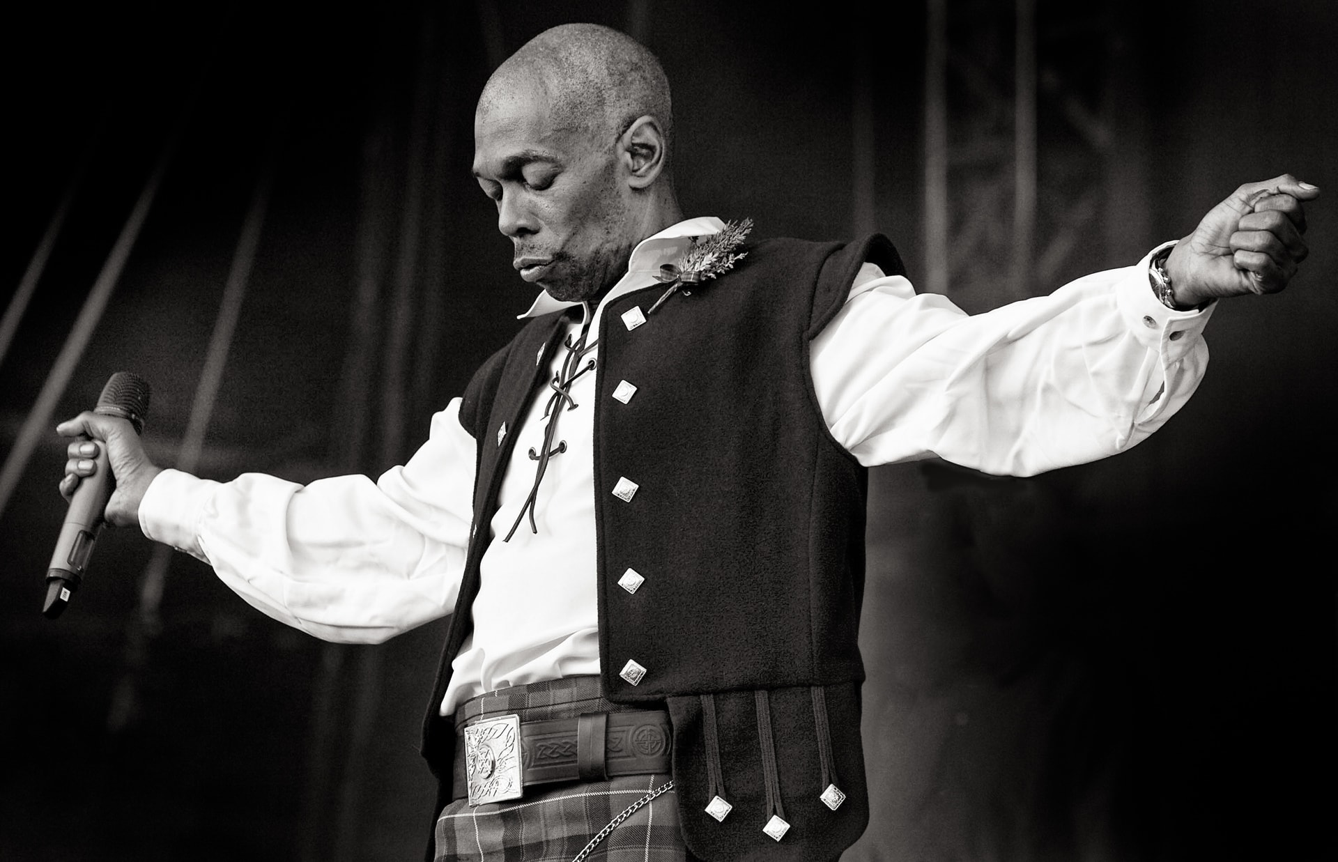 Maxi Jazz of Faithless performing live in black and white, holding a microphone