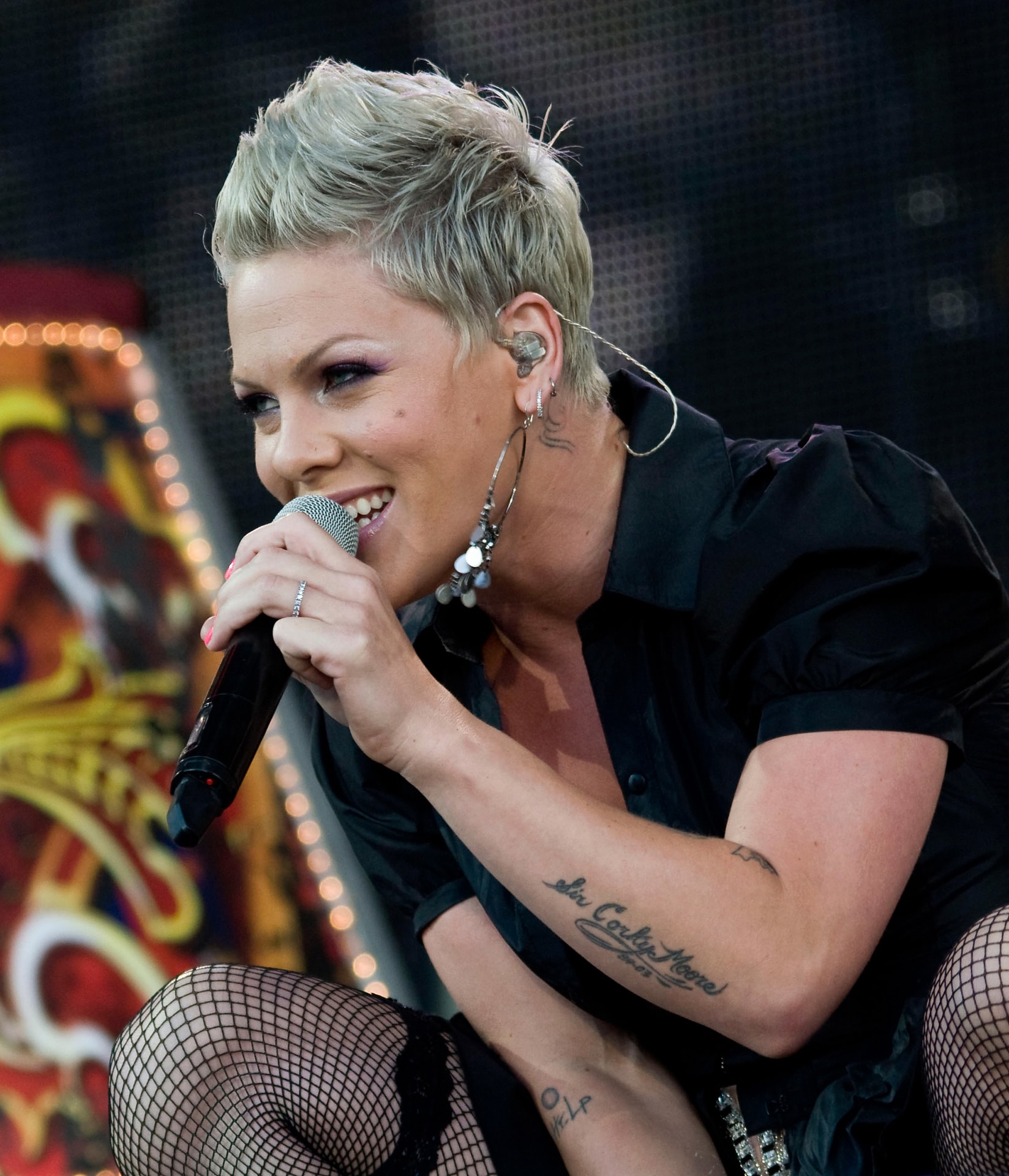 Pink singing into a microphone during a live concert performance
