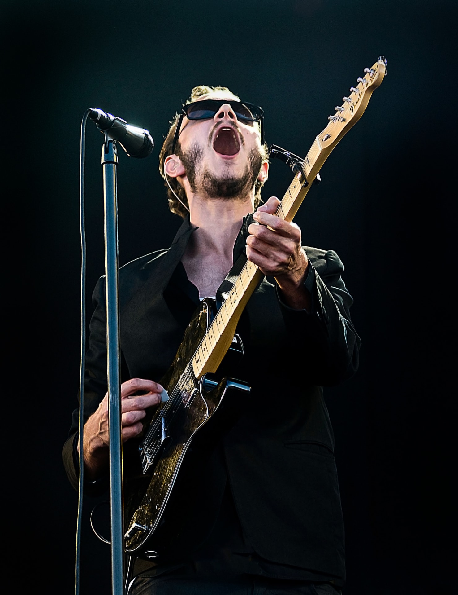 Tom Smith of Editors singing and playing electric guitar live on stage